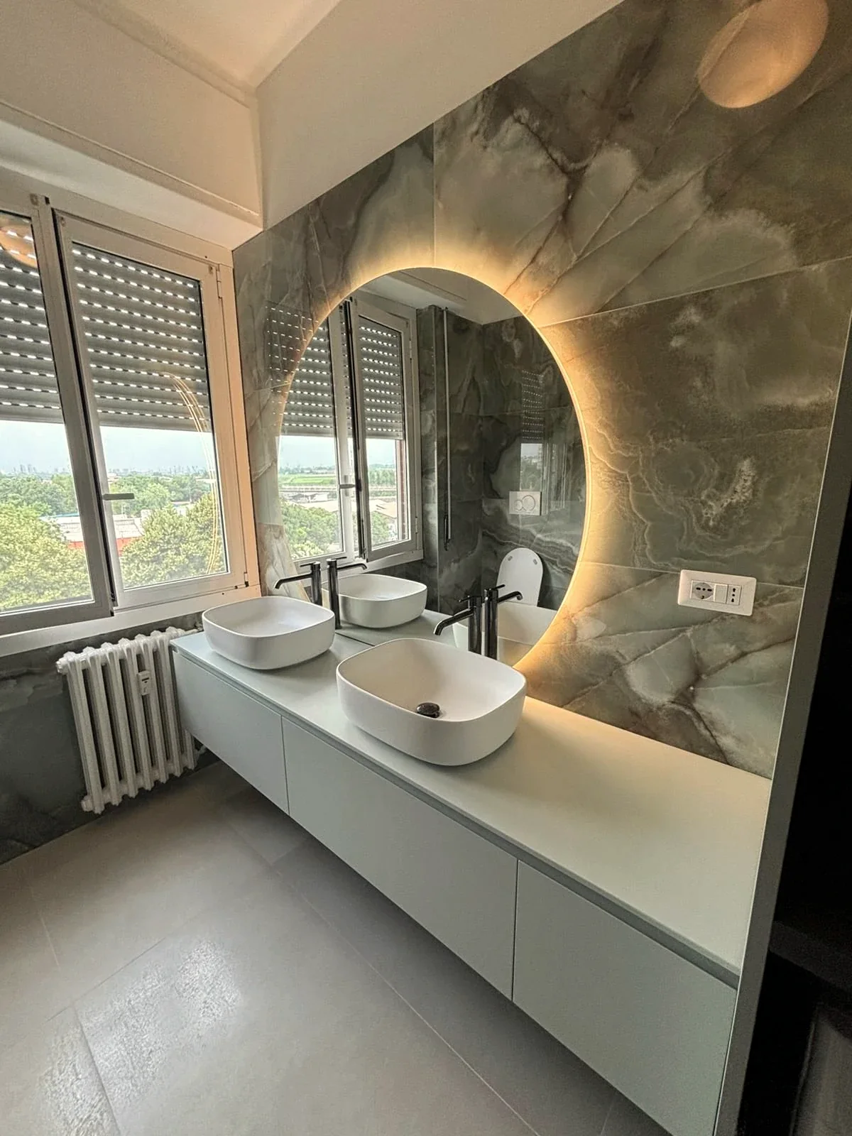 Bagno ristrutturato da Studio Mazzotta con doppio lavabo e specchio retroilluminato