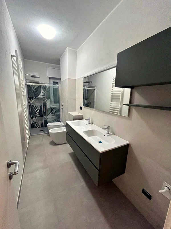 Bagno con nuova disposizione, mobile sospeso scuro e specchio