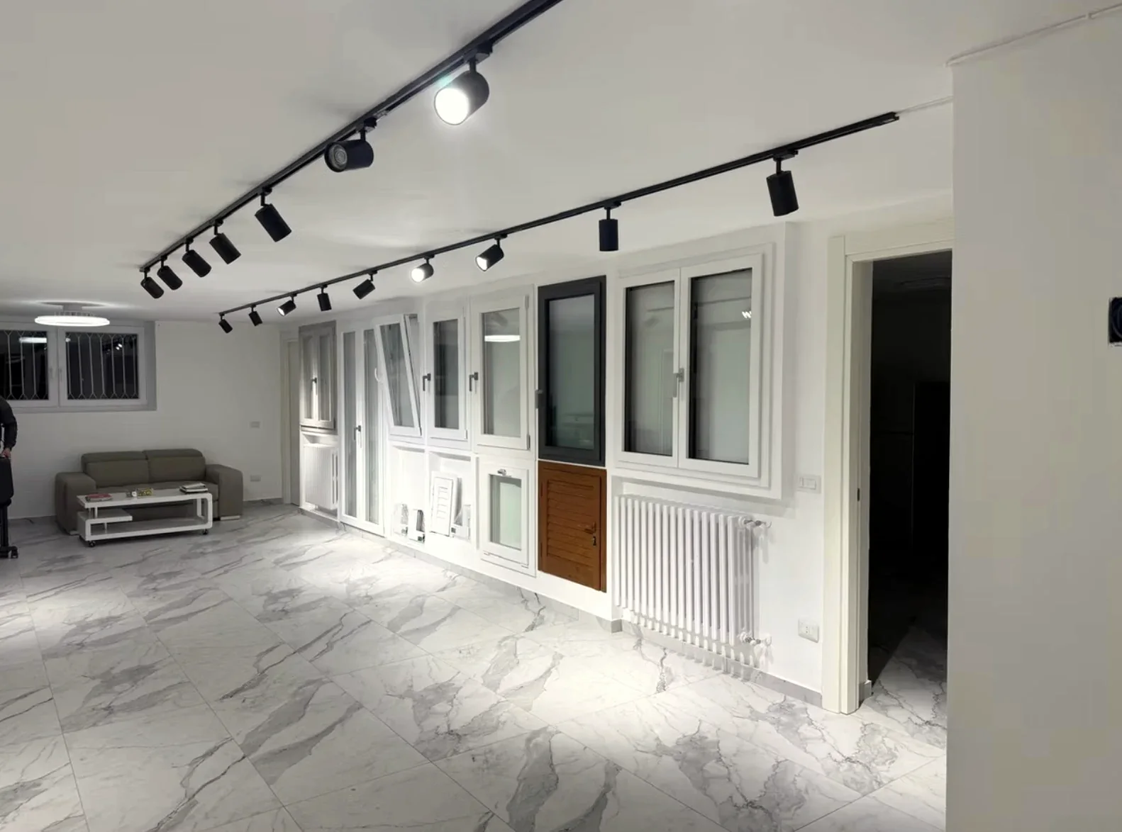 Vista d’insieme di una sala espositiva con finestre, portefinestre e campioni di profili